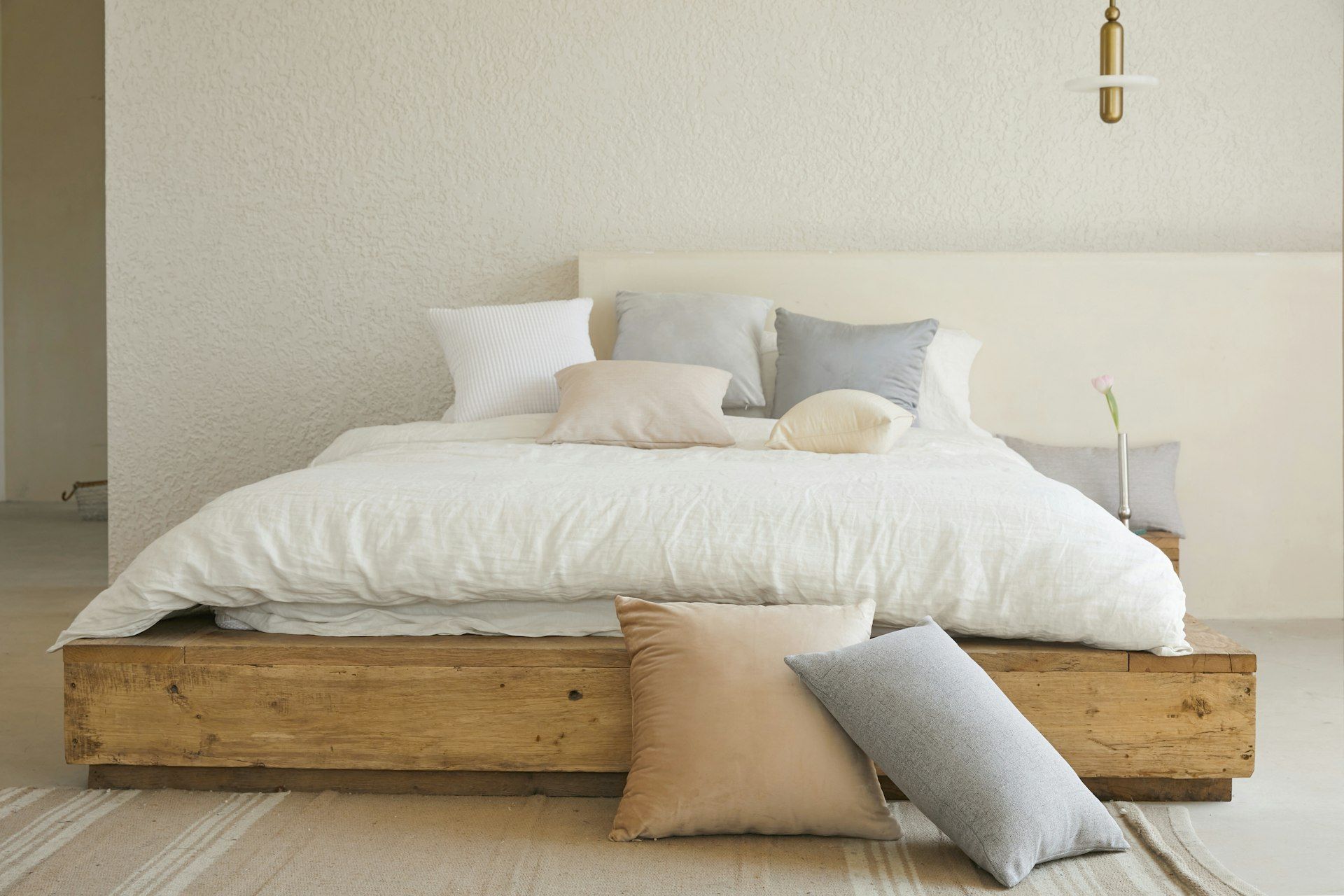 Dormitorio con cama de madera y ropa de cama clara